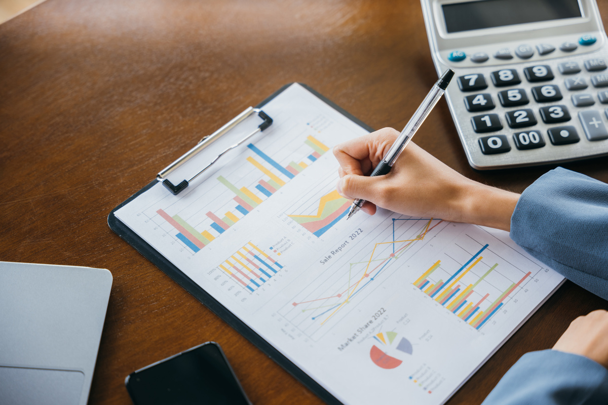 businesswoman working with paperwork charts and graphs and calcu